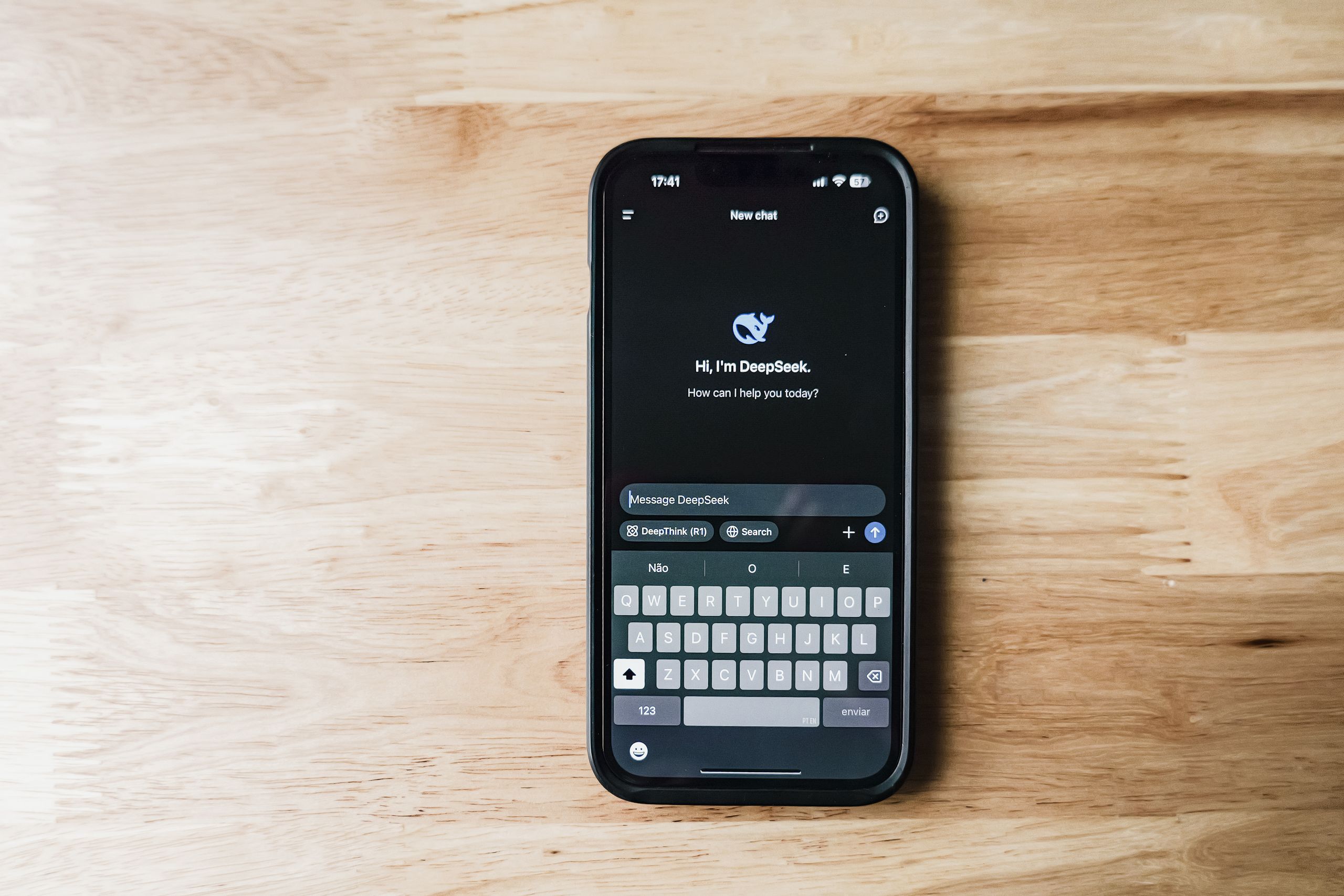 Best AI Writing A smartphone on a wooden table showing an AI chatbot interface called DeepSeek.