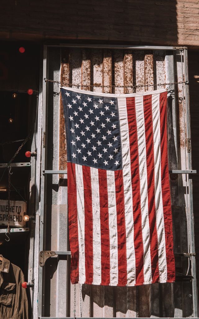 A vertical shot of an American flag hanging on a weathered shed in Valencia, Spain.
