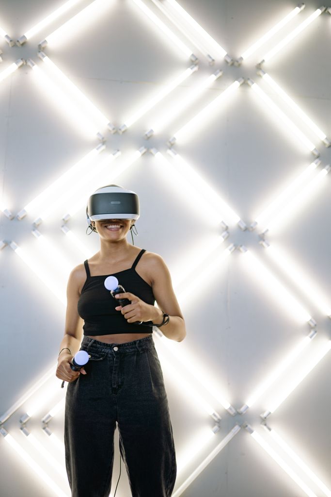 A woman immersed in a virtual reality game using VR headset and controllers against a stylish backdrop.