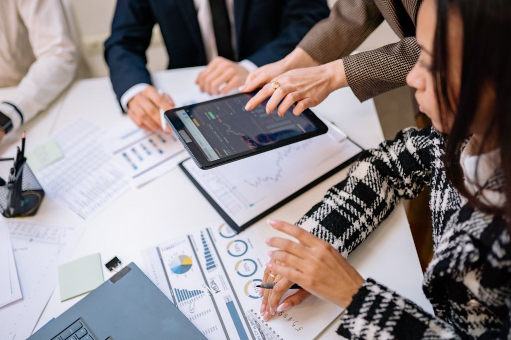 Business professionals Business Technology reviewing analytics on a tablet during a meeting.