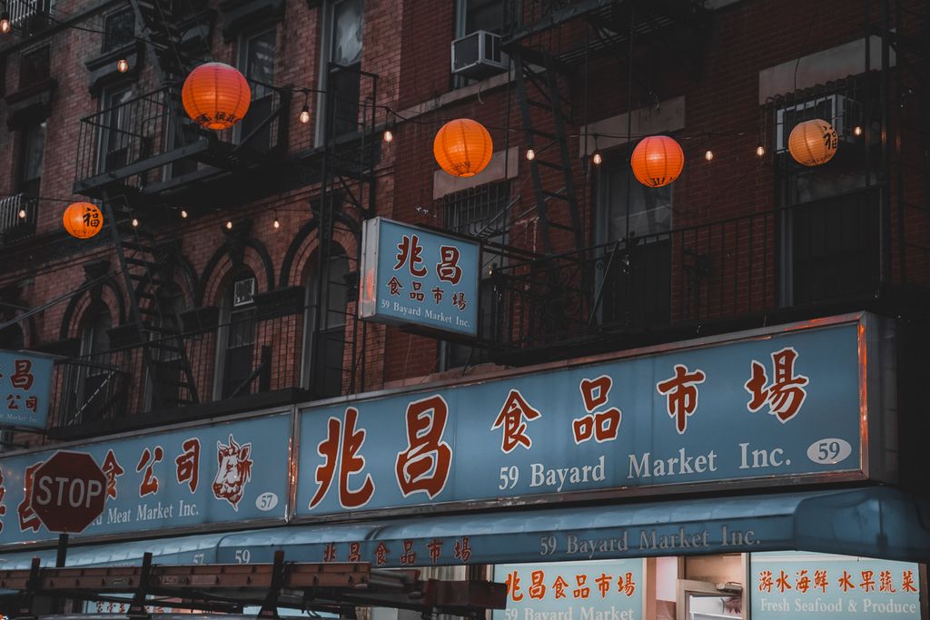 Chinatown buildings in New York City adorned with vibrant lanterns and signs.