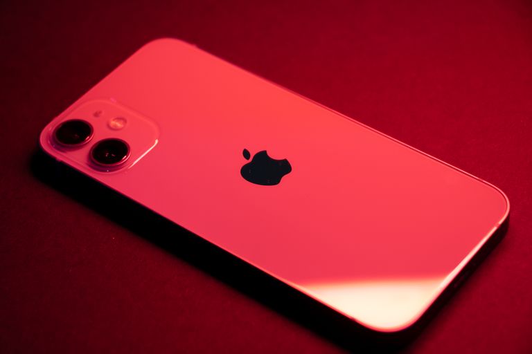 Which iPhone Close-up of a red smartphone with dual lenses on a red backdrop, highlighting sleek design and technology.