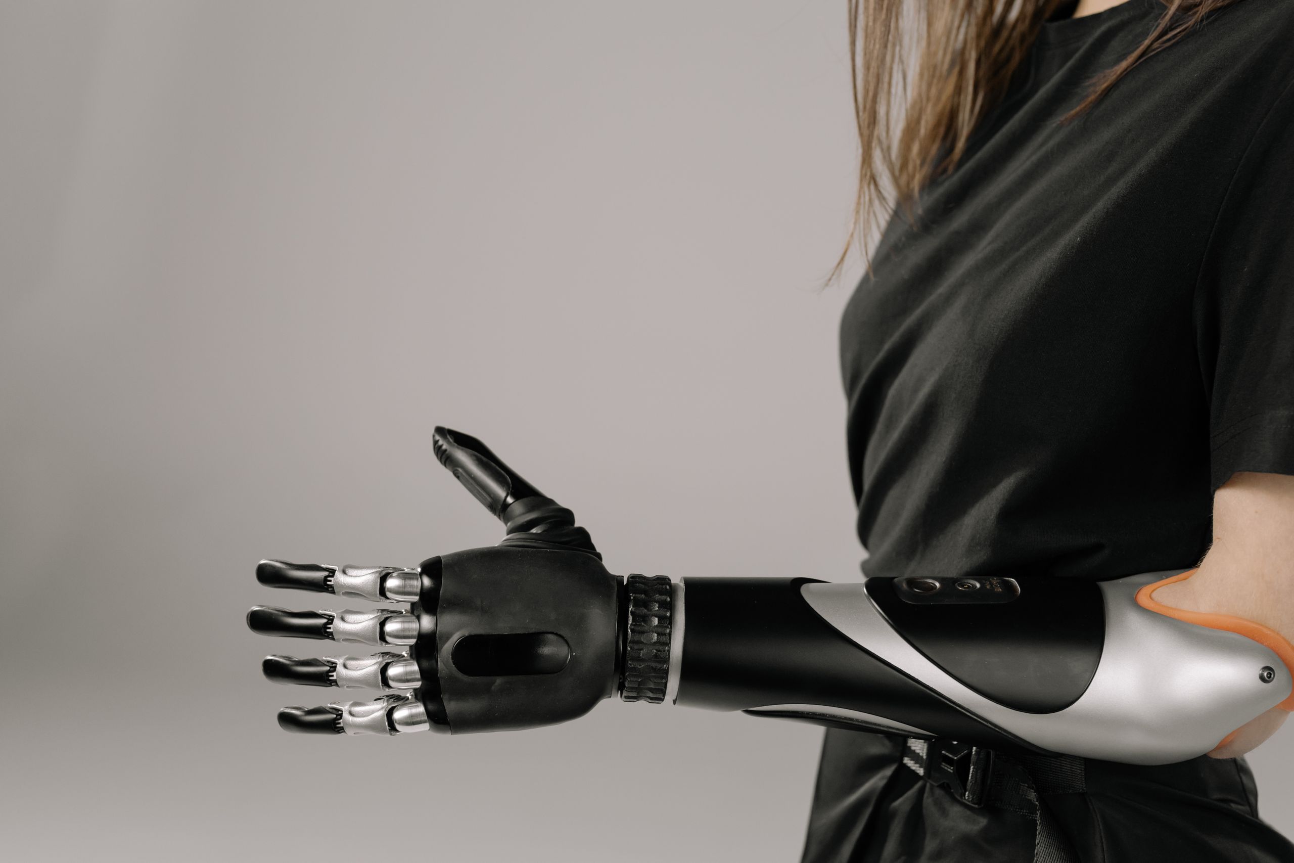 Close-up of a woman wearing a sleek, modern prosthetic arm. Studio shot emphasizes technology and innovation.