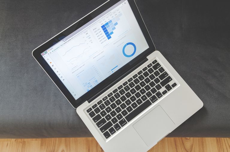 v Overhead view of a laptop showing data visualizations and charts on its screen.