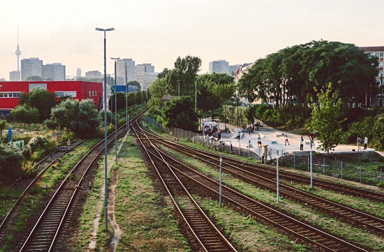 Railway tracks in Berlin with a view of the TV Tower and a nearby skatepark.