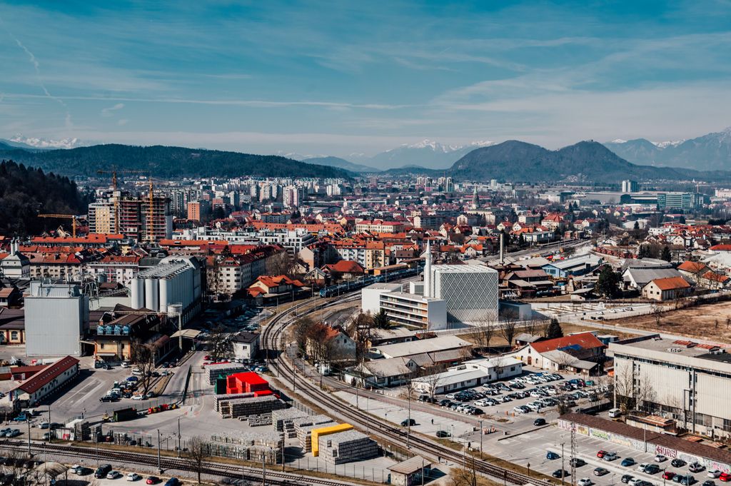 Skyline of Ljubljana with mountains in the backdrop, showcasing urban architecture.