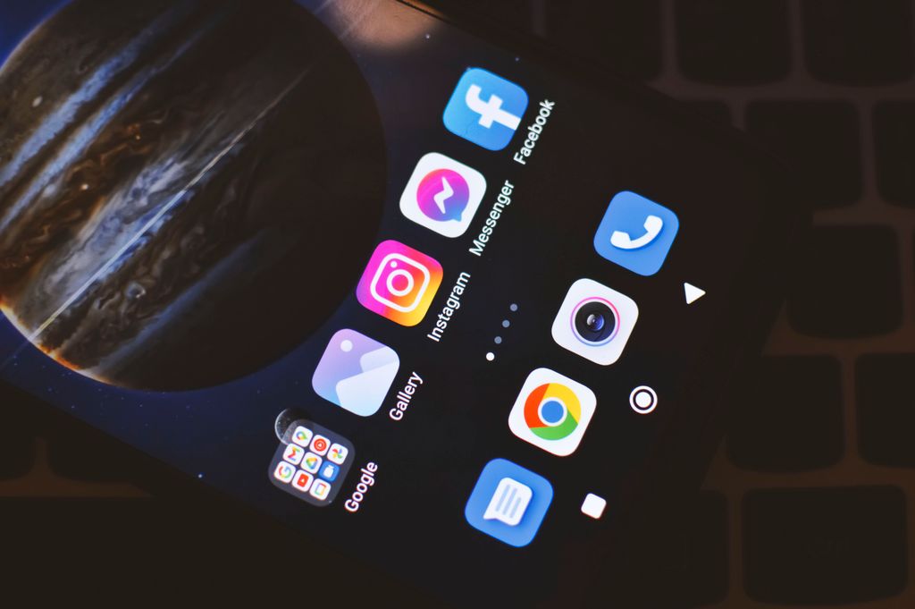 What Is App Designing Smartphone screen showing popular social media and app icons including Facebook and Instagram.