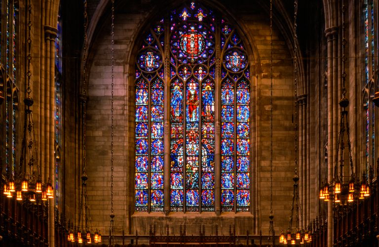 Stunning stained glass window in a Gothic church, featuring intricate designs and vivid colors.