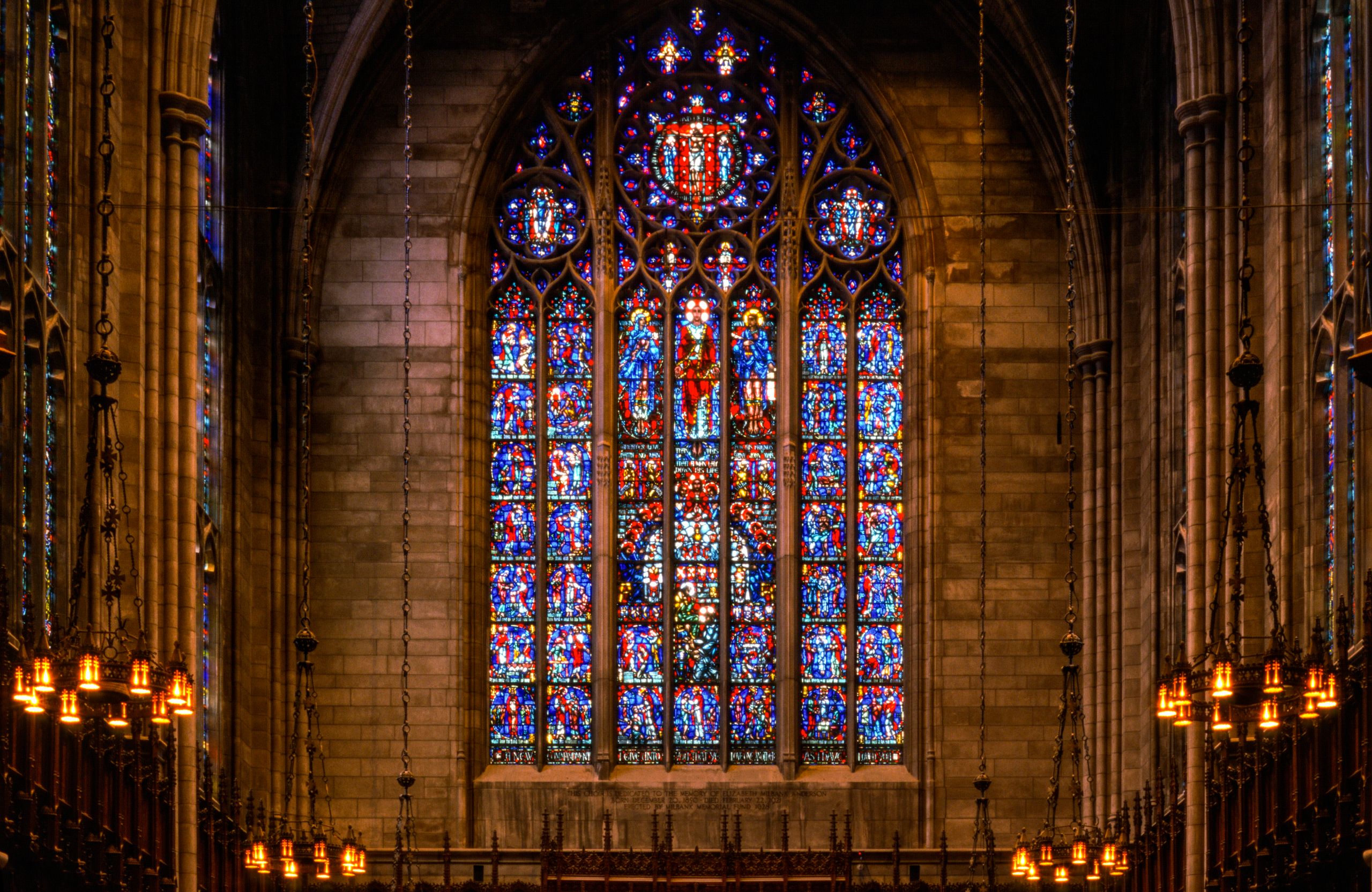 Stunning stained glass window in a Gothic church, featuring intricate designs and vivid colors.