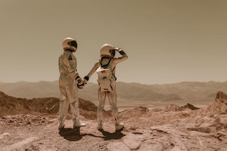 NASA’s New AI-Ready Two astronauts holding hands, exploring rocky Mars-like terrain.