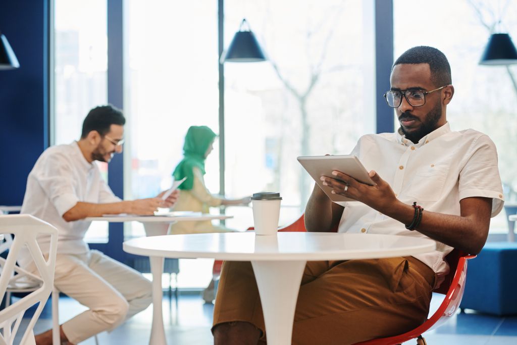 Two professionals using tablets in a contemporary office setting. Collaborative and digital work environment.