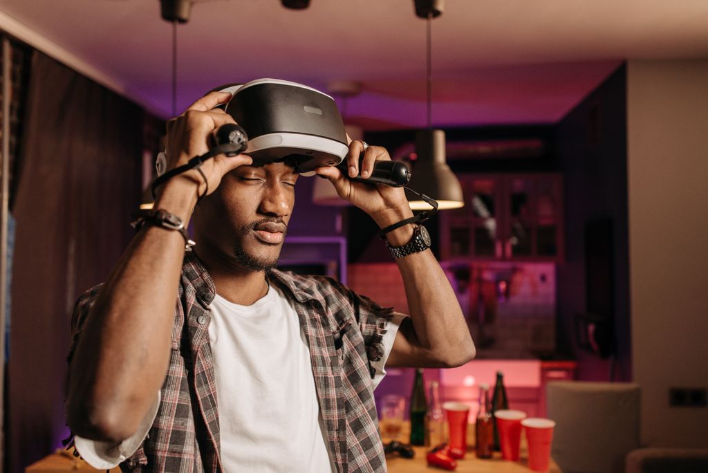 Young adult enjoying virtual reality gaming indoors with VR headset.