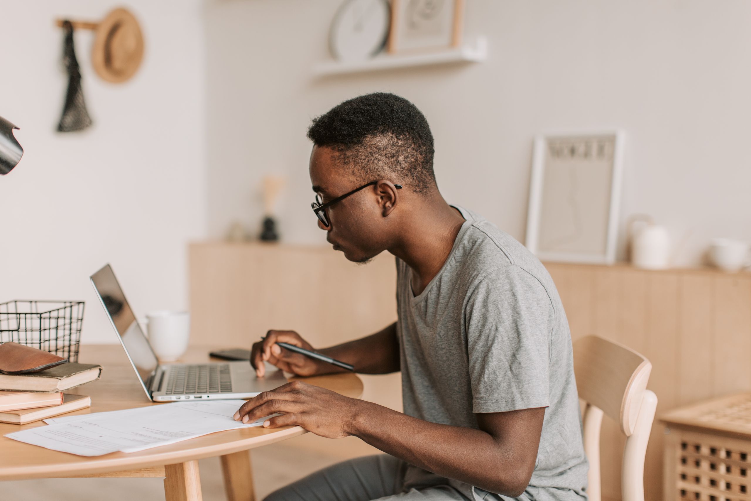 Best AI Tools for Students, Freelancers, Young man working remotely on a laptop indoors, using digital tools for communication.