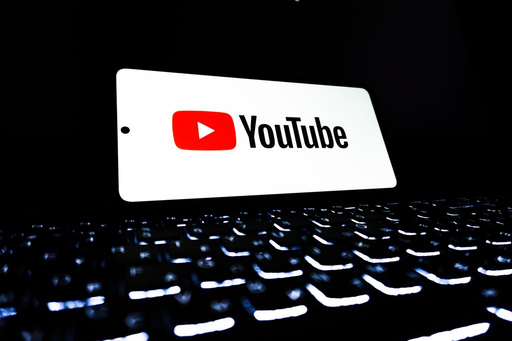 YouTube YouTube app icon displayed on a smartphone over an illuminated keyboard, representing digital media and online streaming.